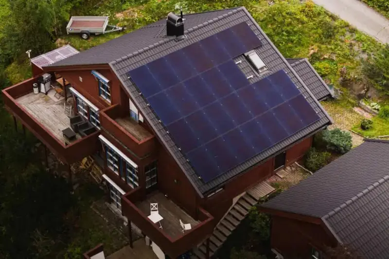 Dom z panelami fotowoltaicznymi na dachu. To rozwiązanie, co to fotowoltaika, pozwala na produkcję własnej energii elektrycznej ze słońca.